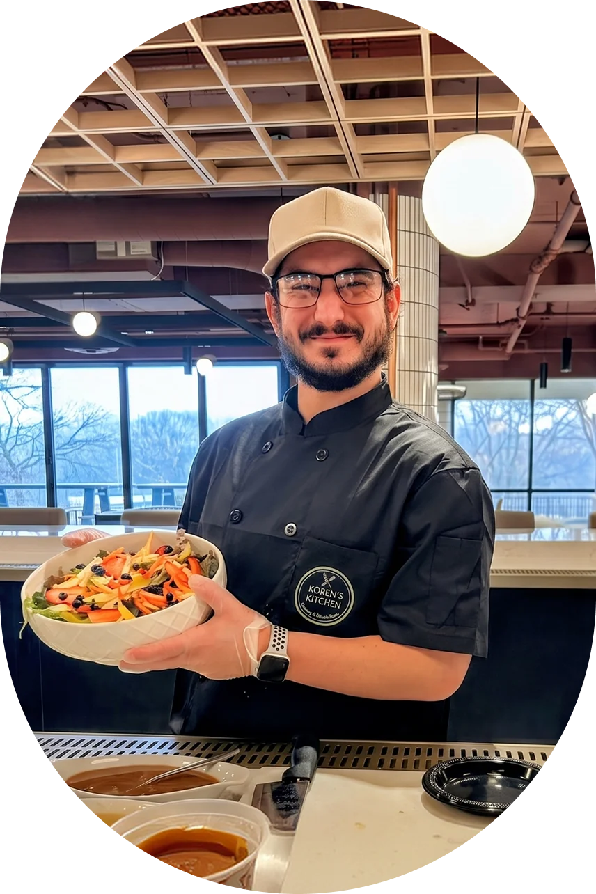 Koren's Kitchen chef holding a large bowl of fresh salad