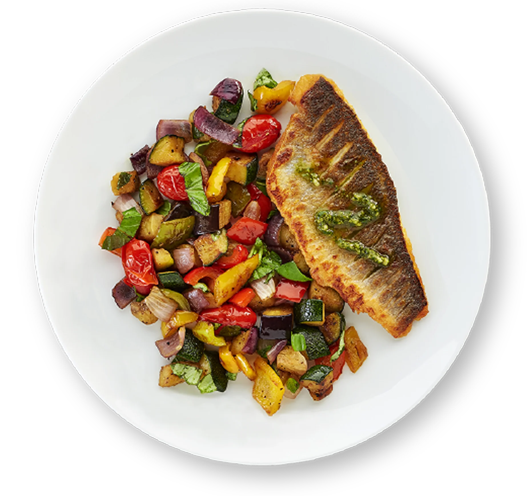 Pan seared fish with roasted vegetables on a white plate