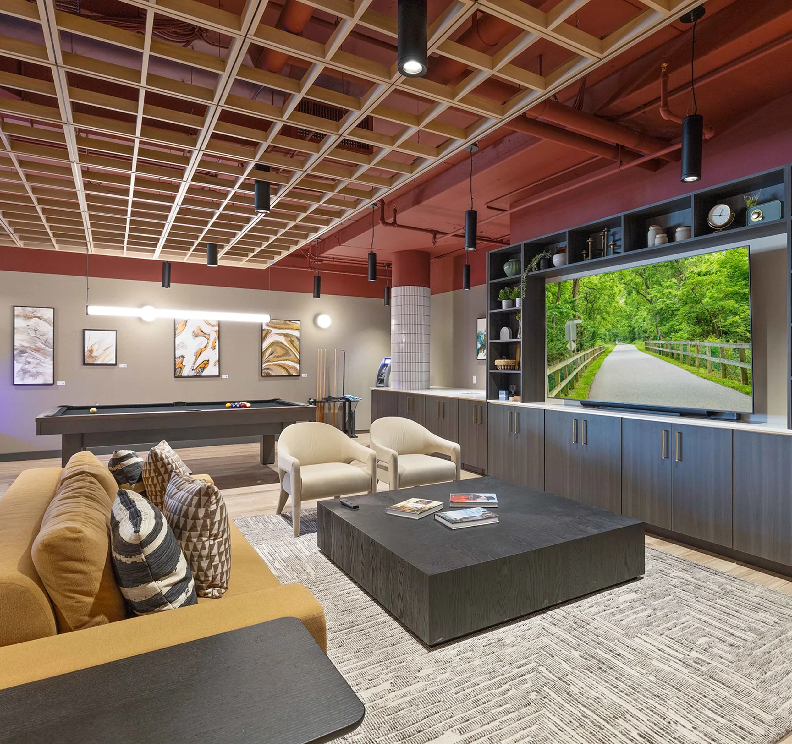 The game room, with a pool table, lounge seating and a large screen