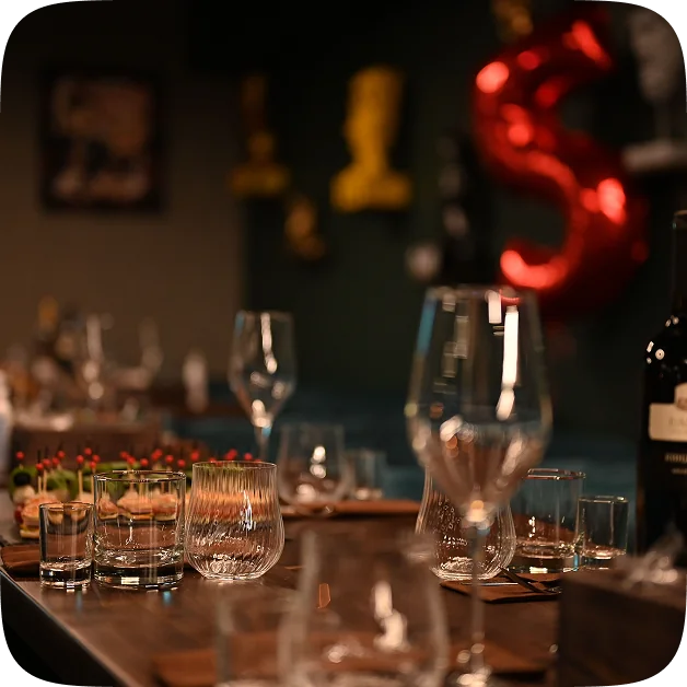 Glassware on a bar counter in a dimly lit lounge