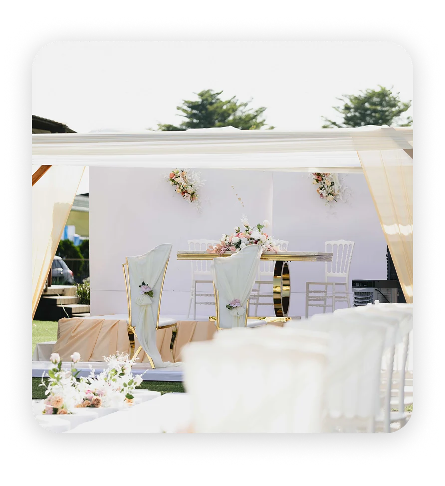 An outdoor event set up with white drapes and flowers