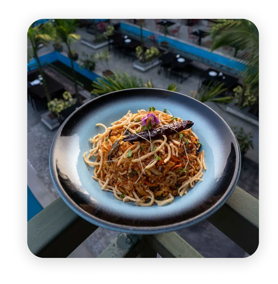 A plate of noodles served beside a pool