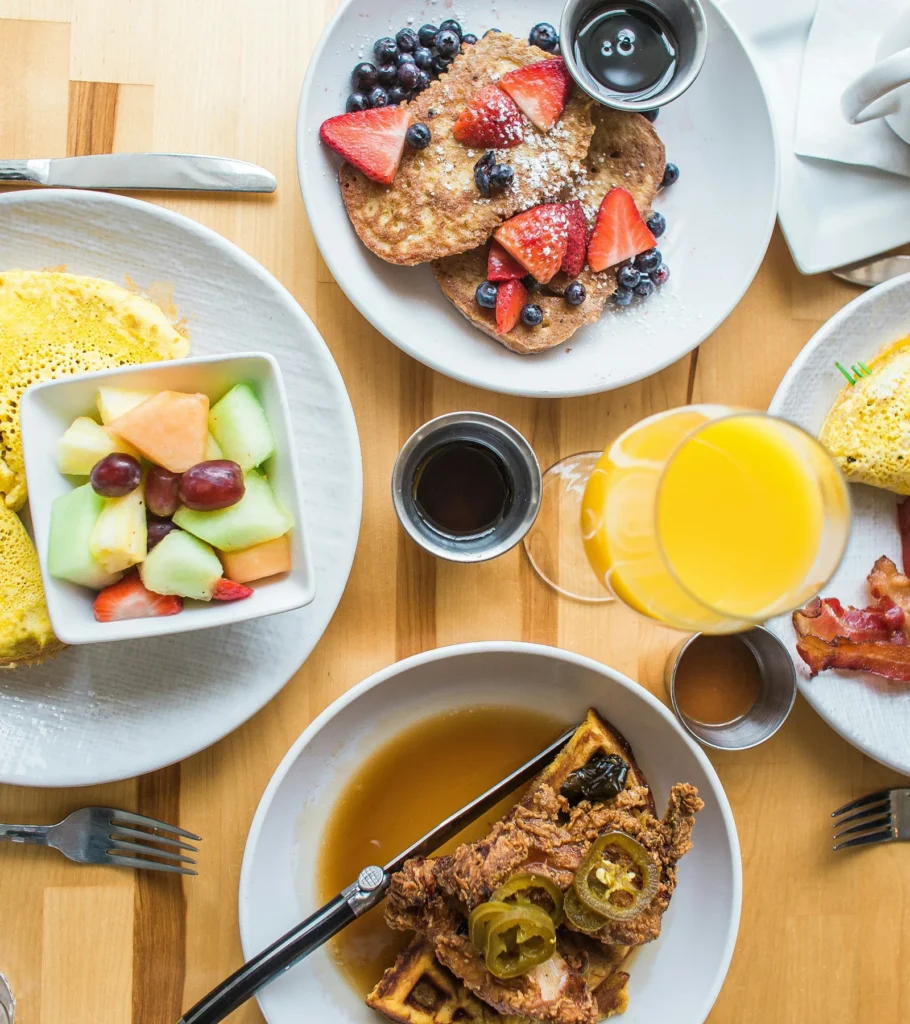 A family brunch spread of French toast, waffles, fruit and juice