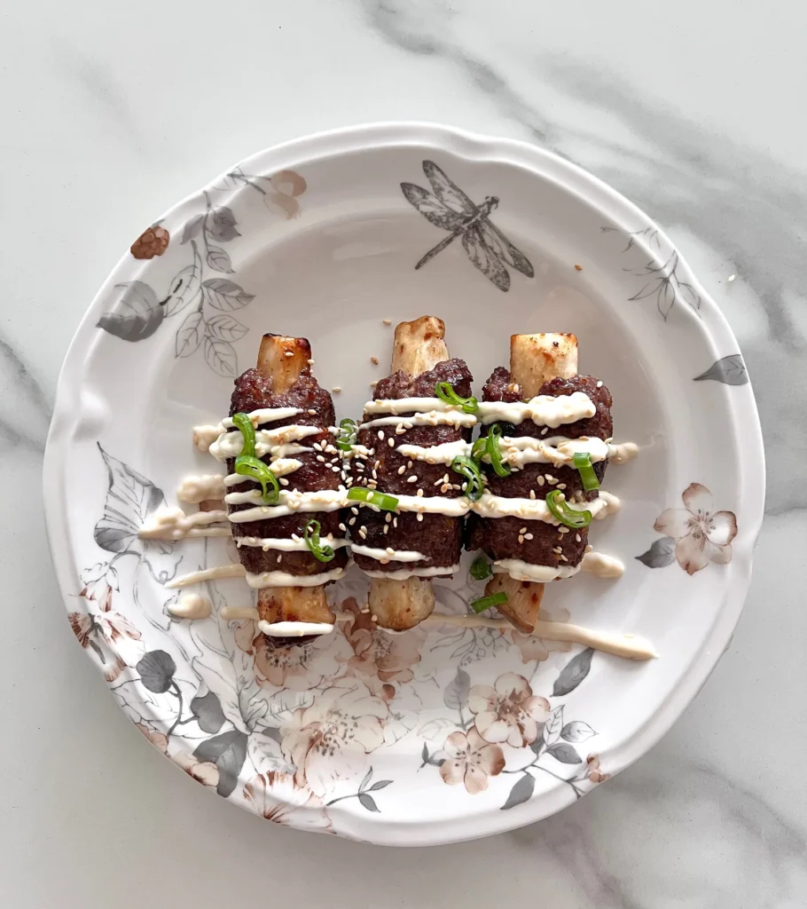 Short rib skewers plated with sauce
